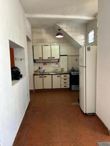 eine Küche mit weißen Schränken und einem Kühlschrank in der Unterkunft Casalinda in Ciudadela