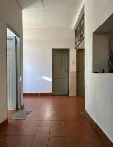 einen leeren Flur mit Tür und Fliesenboden in der Unterkunft Casalinda in Ciudadela
