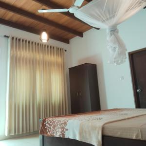 a bedroom with a bed and a ceiling fan at Tharul Home in Bentota