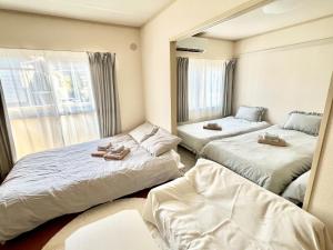a bedroom with two beds and a mirror at Chigasaki JH Court C - Vacation STAY 17903 in Chigasaki