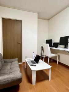 a living room with a couch and a laptop on a coffee table at Chigasaki JH Court C - Vacation STAY 17903 in Chigasaki