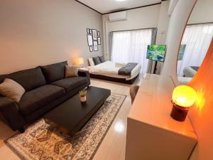 ein Wohnzimmer mit einer Couch und einem Bett in der Unterkunft Lion Heiwa Odori - Vacation STAY 18062 in Hiroshima