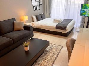 ein Wohnzimmer mit einem Bett und einer Couch in der Unterkunft Lion Heiwa Odori - Vacation STAY 18062 in Hiroshima