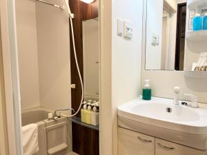 ein Badezimmer mit Waschbecken und Spiegel in der Unterkunft Lion Heiwa Odori - Vacation STAY 18062 in Hiroshima + 19 Fotos