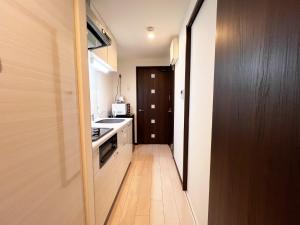 eine kleine Küche mit Spüle und Herd in der Unterkunft Lion Heiwa Odori - Vacation STAY 18062 in Hiroshima