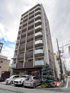 ein hohes Gebäude mit davor geparkt in der Unterkunft Lion Heiwa Odori - Vacation STAY 18061 in Hiroshima