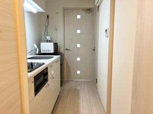 eine kleine Küche mit Spüle und Herd in der Unterkunft Lion Heiwa Odori - Vacation STAY 18061 in Hiroshima
