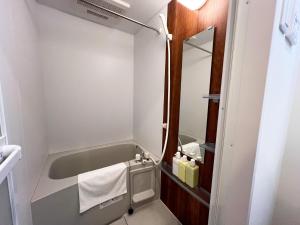 ein kleines Bad mit einer Badewanne und einem Waschbecken in der Unterkunft Lion Heiwa Odori - Vacation STAY 18061 in Hiroshima + 16 Fotos