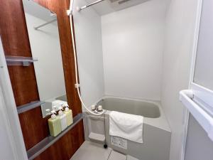 ein kleines Bad mit einer Badewanne und einem Waschbecken in der Unterkunft Lion Heiwa Odori - Vacation STAY 18059 in Hiroshima + 11 Fotos