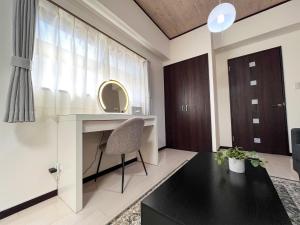 ein Wohnzimmer mit Schreibtisch und Stuhl in der Unterkunft Lion Heiwa Odori - Vacation STAY 17952 in Hiroshima