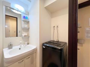 ein kleines Bad mit einem Waschbecken und einem Geschirrspüler in der Unterkunft Lion Heiwa Odori - Vacation STAY 17952 in Hiroshima + 13 Fotos
