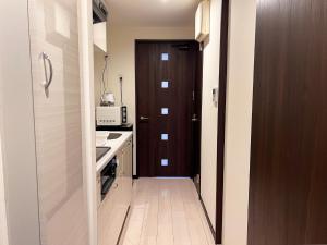 eine Küche mit einer braunen Tür und einer Küchentheke in der Unterkunft Lion Heiwa Odori - Vacation STAY 17952 in Hiroshima