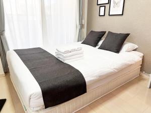 ein Schlafzimmer mit einem großen weißen Bett mit schwarzen Kissen in der Unterkunft Lion Heiwa Odori - Vacation STAY 17954 in Hiroshima