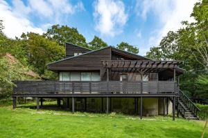 a wooden house with a deck on a lawn at Nasu Premium House - Vacation STAY 17949 in Nasu-yumoto