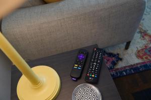 two remote controls sitting on a table next to a lamp at Boston Manor in Indianapolis +22 photos