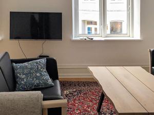 a living room with a couch and a table and a tv at 5 star holiday home in Nakskov in Nakskov +24 photos