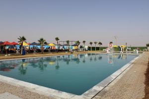 a large swimming pool with blue water at Camping Riad Maissa in Dou Tourga