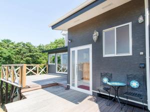 a black house with a deck with a chair on it at dejavu - Vacation STAY 56317v in Manazuru