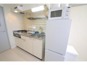 a kitchen with a white refrigerator and a microwave at City Avenue Asahimachi - Vacation STAY 18053 in Sapporo