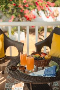 a table with two glasses of juice and a basket of fruit at Zen By The Sea in Betalbatim