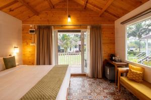 a bedroom with a bed and a large window at Zen By The Sea in Betalbatim