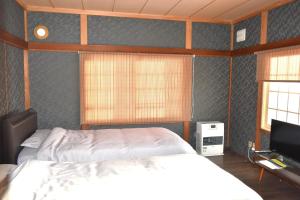 a bedroom with a bed and a flat screen tv at ShiripaYoichi Villa - Vacation STAY 62970v in Kurokawamachi
