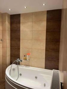 y baño con bañera y azulejos marrones. en Sunnyhomes Livithra, en Leptokarya