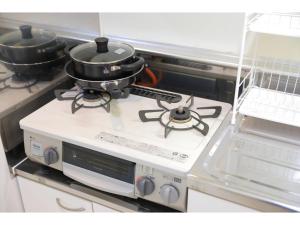 a stove with two pans on top of it at City Avenue Asahimachi - Vacation STAY 18047 in Sapporo