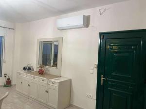 Un baño con una puerta verde, un lavabo y un espejo. en Sunnyhomes Livithra, en Leptokarya 60 fotos más