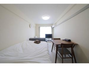 a bedroom with a bed and a table and chair at City Avenue Asahimachi - Vacation STAY 18047 in Sapporo