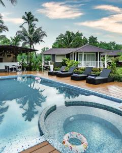 a swimming pool in front of a villa at Zen By The Sea in Betalbatim