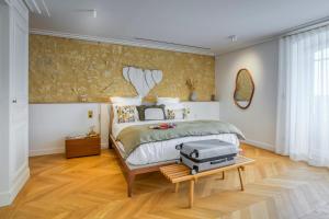 a bedroom with a bed with a suitcase on a table at La Chartreuse du Château La Garde in Martillac
