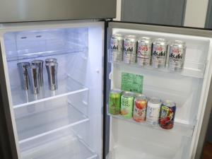 an open refrigerator with drinks and cans of soda at Chocotto Villa Maestro - Vacation STAY 74540v in Sumoto