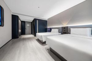 Ένα ή περισσότερα κρεβάτια σε δωμάτιο στο Atour Light Hotel Chongqing Nanbin Road University of Commerce