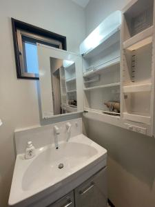 Mare House - Vacation STAY 69168v في Yaka: حمام مع حوض أبيض ومرآة