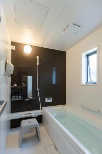 a bathroom with a tub and a stool in it at Guesthouse Ogaki Kokone C, D - Vacation STAY 72631v in Ogaki