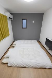 a white bedroom with a large white bed in it at Guesthouse Ogaki Kokone C, D - Vacation STAY 72653v in Ogaki
