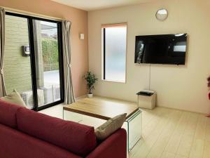 a living room with a red couch and a large window at Building A - Vacation STAY 72692v in Kikuchi