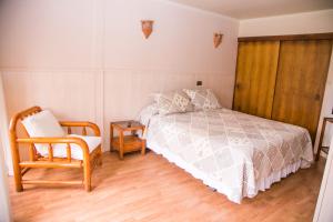 1 dormitorio con 1 cama y 1 silla en Cabañas Las Añañucas I, en La Serena