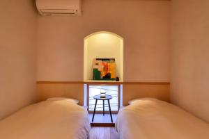 two beds in a room with a small table at Kazekuru - Vacation STAY 18924 in Fujiyoshida