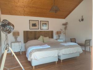 una camera con letto, ventilatore e scrivania di Suite no campo a Cercal