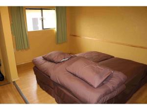 un petit lit dans une chambre avec une fenêtre dans l'établissement SUNSEA COTTAGE - Vacation STAY 82148v, à Tagawa