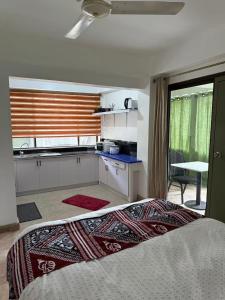 a bedroom with a kitchen and a bed in a room at CC Beach villa in wailoaloa in Nadi