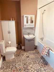 a bathroom with a sink and a toilet and a tub at SNUZE Whitby 2 in Whitby +43 photos