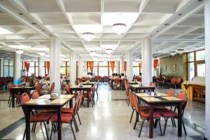 a restaurant with tables and chairs and people sitting at tables at Hotel Astoria in Mamaia