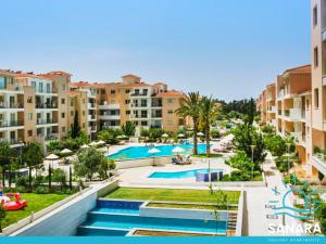 una imagen de una piscina en un resort en Elysia Park Sanara Holiday Apartments, en Pafos