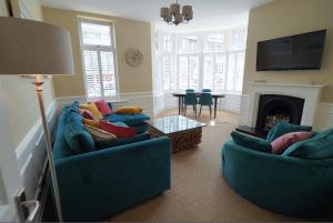 a living room with two blue couches and a fireplace at Ruby Sands in Saltburn-by-the-Sea