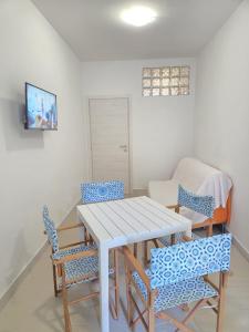 フォッローニカにあるAppartamento Morelli Beach - Via Colomboの白いテーブルと椅子のあるダイニングルーム +4枚の写真