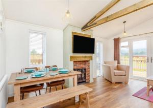 a living room with a table and a fireplace at Sanctuary Pathfinder Lodge in Fort Augustus