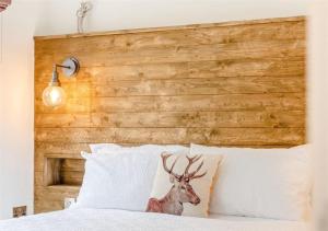 a wooden headboard with a deer head on a bed at Sanctuary Pathfinder Lodge in Fort Augustus